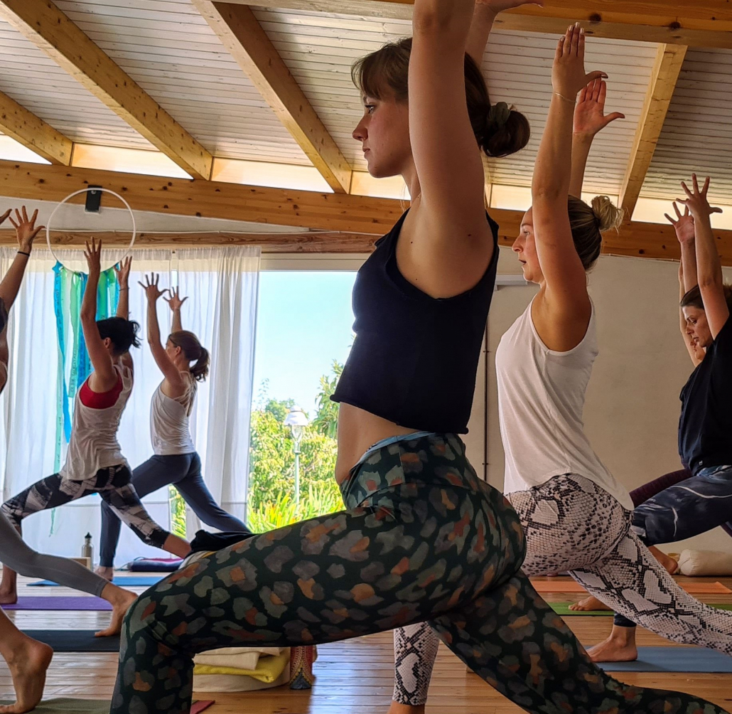 Teilnehmer üben Yoga in licht durchflutet Raum während Yogalehrerausbildung