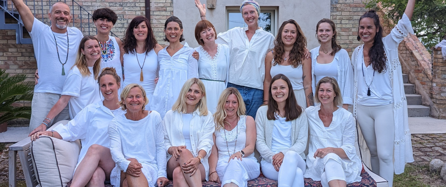 Teilnehmerinnen der Yogalehrerausbildung bei Gruppenbild im Weiß gekleidet